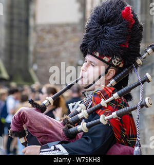 Eine Piper unterhält Passanten in der Nähe von Edinburgh Castle auf der Royal Mile, Edinburgh, Schottland, Großbritannien. Stockfoto