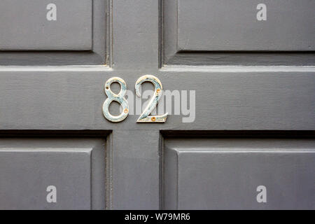 Haus Nummer 82 auf einem grauen Holz- Vordertür Stockfoto