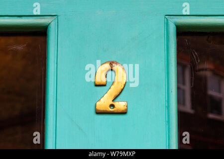 Goldene Haus Nummer zwei auf einem türkisfarbenen Tür Stockfoto