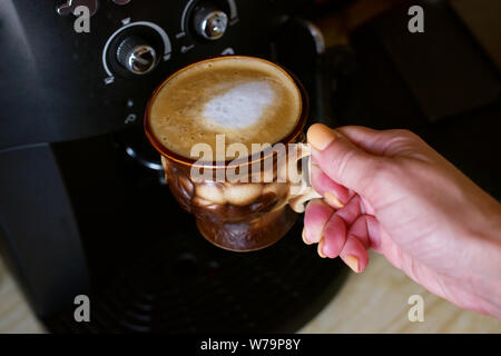 Kaffee. Frisch Flache weiße gemacht. Eine Reihe von Fotos mit einem Cappuccino Kaffee trinken in einem braunen Schale Stockfoto