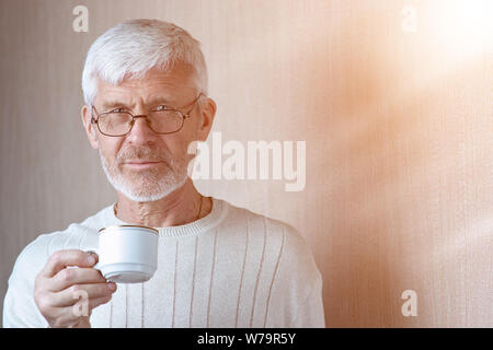 Porträt der grauhaarige Mann mit einer Tasse Kaffee Stockfoto
