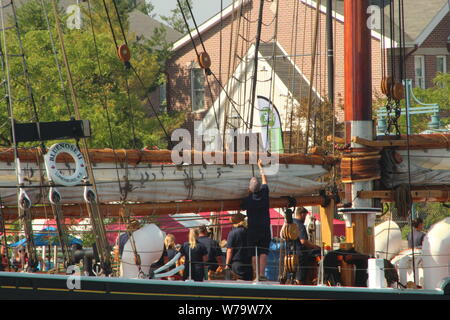 Ein Crew Mitglied der Pride of Baltimore II bereitet die Segel vor der Abreise des Tall Ship aus Kenosha Harbor im August 2019. Stockfoto