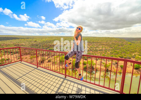 Glückliche kaukasische Frau genießt die Aussicht auf die Schlucht des Murchison River von der Aussichtsplattform Hawks Head im Kalbarri National Park, Westaustralien. Blond Stockfoto