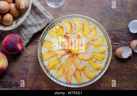 Der Pfirsich Kuchen bereit, auf Holztisch zu backen. Stockfoto