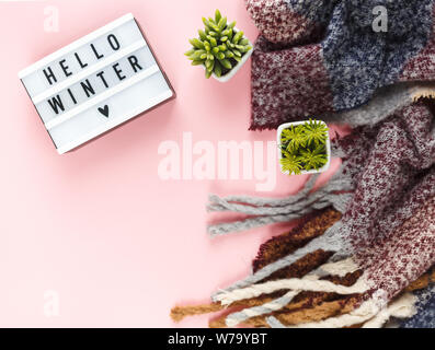 Weihnachten Konzept flach. Warme, gemütliche weiß winter Pullover Kleidung, Lightbox und Weihnachtsschmuck Rahmen auf Rosa pastell Hintergrund Stockfoto