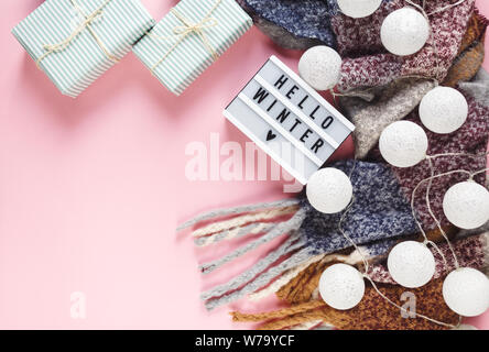 Weihnachten Konzept flach. Warme, gemütliche weiß winter Pullover Kleidung, Lightbox und Weihnachtsschmuck Rahmen auf Rosa pastell Hintergrund Stockfoto