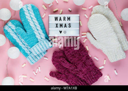 Warme, gemütliche winter Bekleidung, Lightbox und weihnachtsschmuck als Frame auf Pastell rosa Hintergrund. Weihnachten Konzept flach. warme Weihnachten Titel Stockfoto