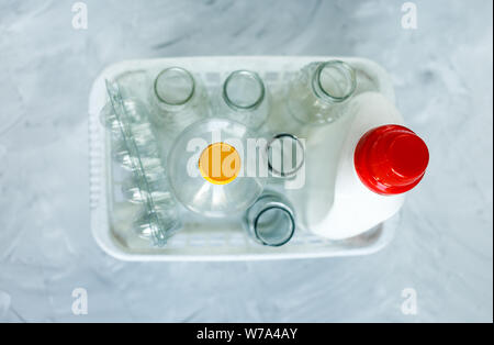 Flach unterschiedlicher Abfälle bereit für das Recycling in weiß Warenkorb. Kunststoff, Glas, Papier. Soziale Verantwortung, Ökologie, Recycling zu Hause Stockfoto