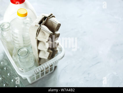 Flach unterschiedlicher Abfälle bereit für das Recycling in weiß Warenkorb. Kunststoff, Glas, Papier. Soziale Verantwortung, Ökologie, Recycling zu Hause Stockfoto