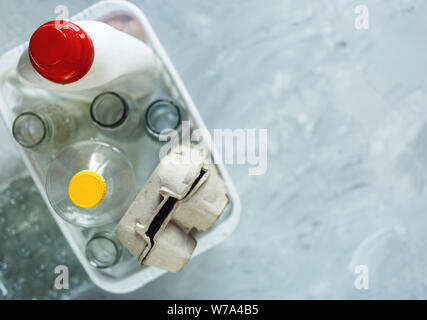 Flach unterschiedlicher Abfälle bereit für das Recycling in weiß Warenkorb. Kunststoff, Glas, Papier. Soziale Verantwortung, Ökologie, Recycling zu Hause Stockfoto