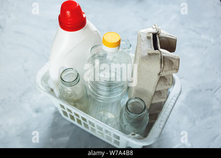 Flach unterschiedlicher Abfälle bereit für das Recycling in weiß Warenkorb. Kunststoff, Glas, Papier. Soziale Verantwortung, Ökologie, Recycling zu Hause Stockfoto