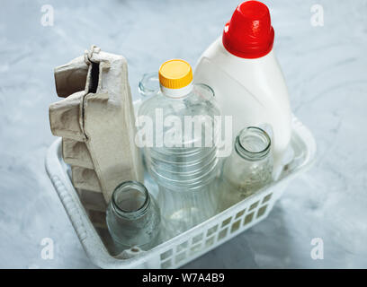 Flach unterschiedlicher Abfälle bereit für das Recycling in weiß Warenkorb. Kunststoff, Glas, Papier. Soziale Verantwortung, Ökologie, Recycling zu Hause Stockfoto