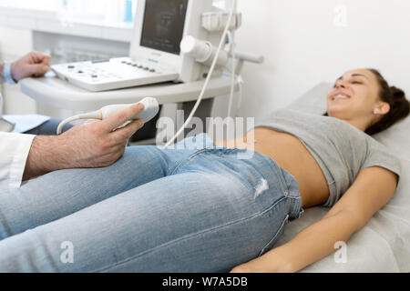 Junge Frau in 4D Ultraschall. Die Ultraschalldiagnostik, die Untersuchung des Abdomens. Stockfoto