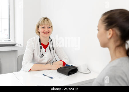 Der Arzt an der terapevt kommuniziert mit den Patienten in der Klinik. Stockfoto