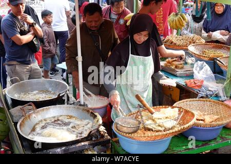 Jakarta, Indonesien - August 2019: ein Mann & Frau Paar zusammen kochen im eigenen Street Food stall. Stockfoto