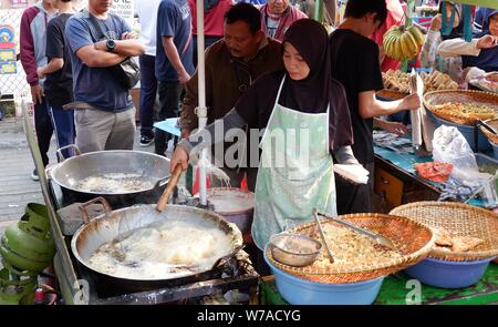 Jakarta, Indonesien - August 2019: ein Mann & Frau Paar zusammen kochen im eigenen Street Food stall. Stockfoto