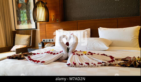 Origami Schwäne aus Handtüchern auf dem Bett in die Flitterwochen Suite im Luxushotel Stockfoto