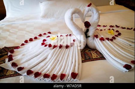 Origami Schwäne aus Handtüchern auf dem Bett in die Flitterwochen Suite im Luxushotel Stockfoto