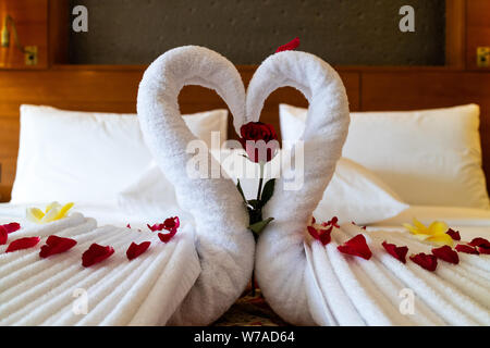 Origami Schwäne aus Handtüchern auf dem Bett in die Flitterwochen Suite im Luxushotel Stockfoto