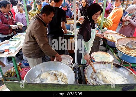 Jakarta, Indonesien - August 2019: ein Mann & Frau Paar braten Snacks zum Verkauf im eigenen Street Food stand. Stockfoto