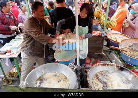 Jakarta, Indonesien - August 2019: ein Mann & Frau Paar braten Snacks zum Verkauf im eigenen Street Food stand. Stockfoto