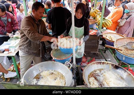 Jakarta, Indonesien - August 2019: ein Mann & Frau Paar braten Snacks zum Verkauf im eigenen Street Food stand. Stockfoto