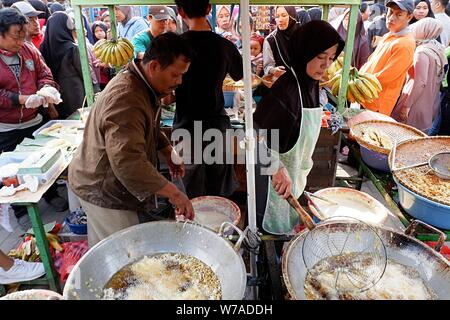 Jakarta, Indonesien - August 2019: ein Mann & Frau Paar braten Snacks zum Verkauf im eigenen Street Food stand. Stockfoto