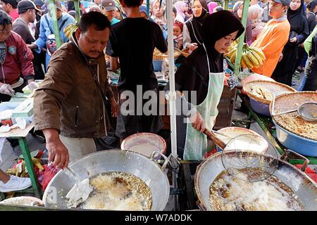 Jakarta, Indonesien - August 2019: ein Mann & Frau Paar braten Snacks zum Verkauf im eigenen Street Food stand. Stockfoto