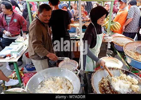 Jakarta, Indonesien - August 2019: ein Mann & Frau Paar braten Snacks zum Verkauf im eigenen Street Food stand. Stockfoto