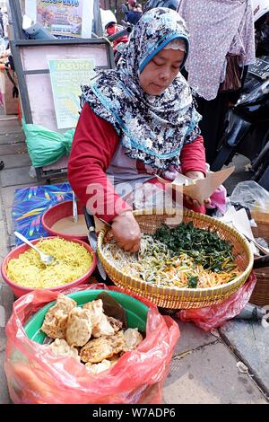 Eine Frau Street Food Unternehmer bereitet die Bestellung Ihres Kunden. Stockfoto