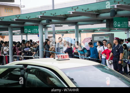 Anwohner auf Warteschlange in einer langen Linie für Taxis Aufgrund der bus Störung durch Taifun Khanun in Macau, China, 15. Oktober 2017 zu warten. Typhoon K Stockfoto