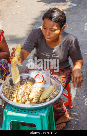 Yangon, Myanmar - 4. Mai 2014: Eine Frau verkaufen Mais auf der Straße. Viele Märkte haben Anbieter Verkauf von Speisen. Stockfoto