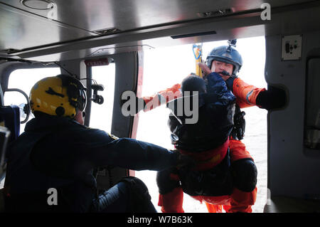 Die angeln Enthusiasten in die raue See blockiert ist durch ein Retter von Beihai Rescue Präsidium des Bundesministeriums für Verkehr in einem Hubschrauber in Dongyin gespeichert Stockfoto