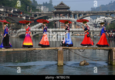 Chinesische Mädchen von Miao ethnische Minderheit im traditionellen Silber gekleidet - gestaltete Kleidung und headwears durchführen auf der Tuo Tuojiang River (Fluss) im F Stockfoto