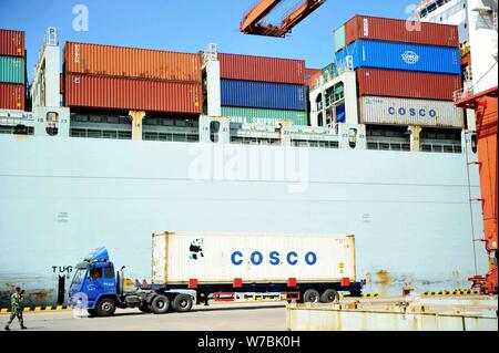 ---- Ein LKW-Transporte einen Behälter mit Cosco im Ausland auf einem Kai im Hafen von Qingdao in Qingdao Stadt versandt, der ostchinesischen Provinz Shandong, Stockfoto