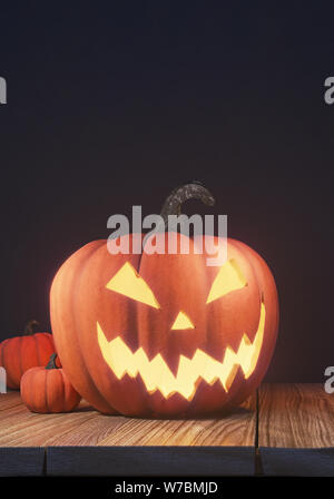 Halloween Pumpkin Head jack Lantern auf hölzernen Planken und schwarzem Hintergrund, gespenstische Nacht, 3D-Rendering, 3D-Darstellung Stockfoto