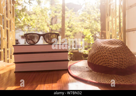Vorderansicht des Buch- und Sonnenbrille mit einem Strohhut. Sommer Urlaub Hintergrund Konzept. Stockfoto