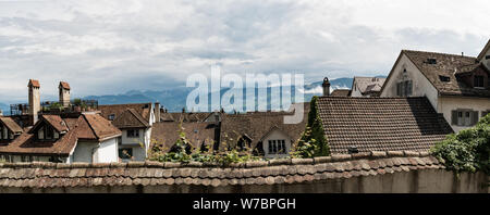 Ein Panorama der alten Häuser und Dächer in Europa mit Berglandschaft hinter Stockfoto