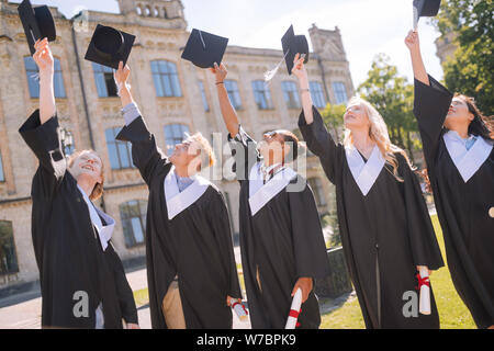 Gerne Studenten ihre Meister Kappen zusammen. Stockfoto