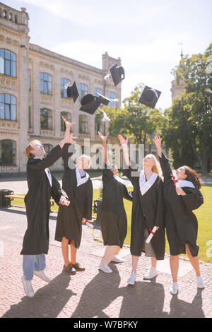 Absolventen ihre Herren Caps bis zu werfen. Stockfoto