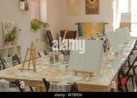 Russland, Tatarstan, 21. April 2019. Kinder- zeichnung Klasse. Staffelei, Leinwände, Farben auf dem Tisch. Warten auf die Teilnehmer. Innenraum der Kunstschule fo Stockfoto