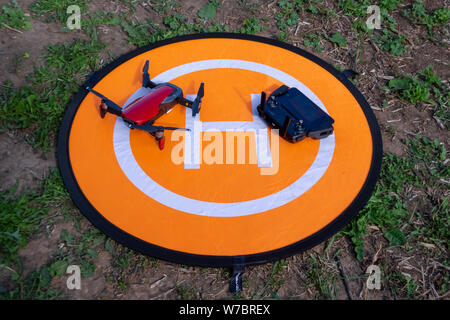 Russland, Tatarstan, 15. Juni 2019. Brummen auf der heliport.Drone Telefon- und Control Panel auf eine orange Hubschrauberlandeplatz auf dem Gras. Stockfoto