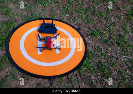 Russland, Tatarstan, 15. Juni 2019. Brummen auf der heliport.Drone Telefon- und Control Panel auf eine orange Hubschrauberlandeplatz auf dem Gras. Stockfoto