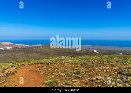 Spanien, Lanzarote, blauen Atlantik Wasser hinter endlosen Felder von Kakteen und Weinbau in der Nähe von ihr Stockfoto