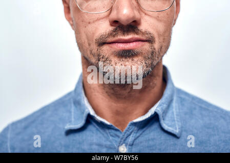 Look perfekt. 7/8-Foto von bärtigen Mann in Brillen bei Camera suchen, während gegen grauen Hintergrund stehen. Männer Schönheit. Studio gedreht. Menschliches Gesicht Stockfoto