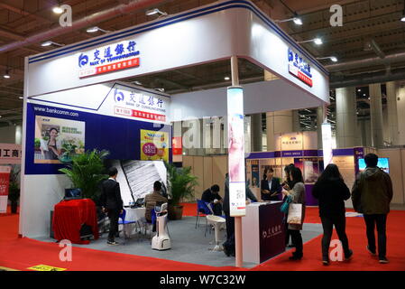 ---- Leute besuchen den Stand der Bank der Kommunikation während einer Ausstellung in Dalian im Nordosten der chinesischen Provinz Liaoning, am 25. November 2016. Stockfoto