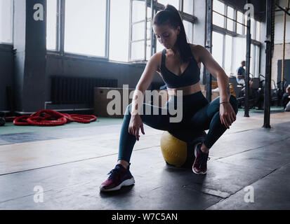 Erholung, Wohlbefinden und Sport Konzept. Motivierte Sportlerin workout Fitness Club, sitzen Fitnessstudio lächeln Kamera, Schweiß von der Stirn wischen, Lean Medizin b Stockfoto