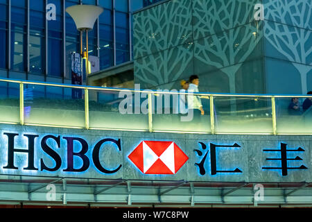 ---- Fußgänger vorbei an einer Werbung für HSBC (Hongkong und Shanghai Banking Corporation Limited) in Shanghai, China, 31. August 2017. Stockfoto