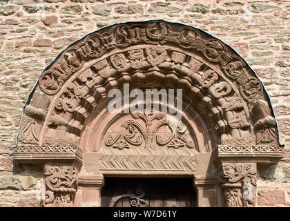 Arch mit kunstvollen Schnitzereien über Süden Tür. Einschließlich der Engel in der Mitte. Kirche St. Maria und St. David, Kilpeck, Herefordshire Stockfoto