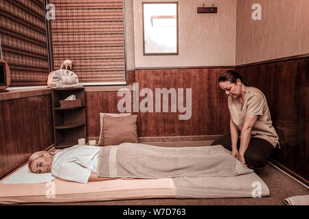 Glückliche Frau vorbereiten für Ihre Massage. Stockfoto
